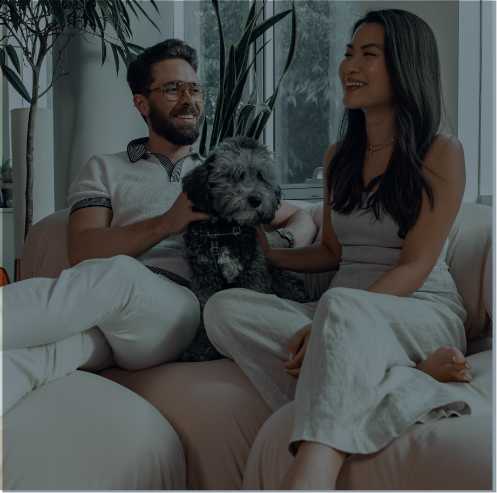 Pareja sentada en un sofá con un perro
